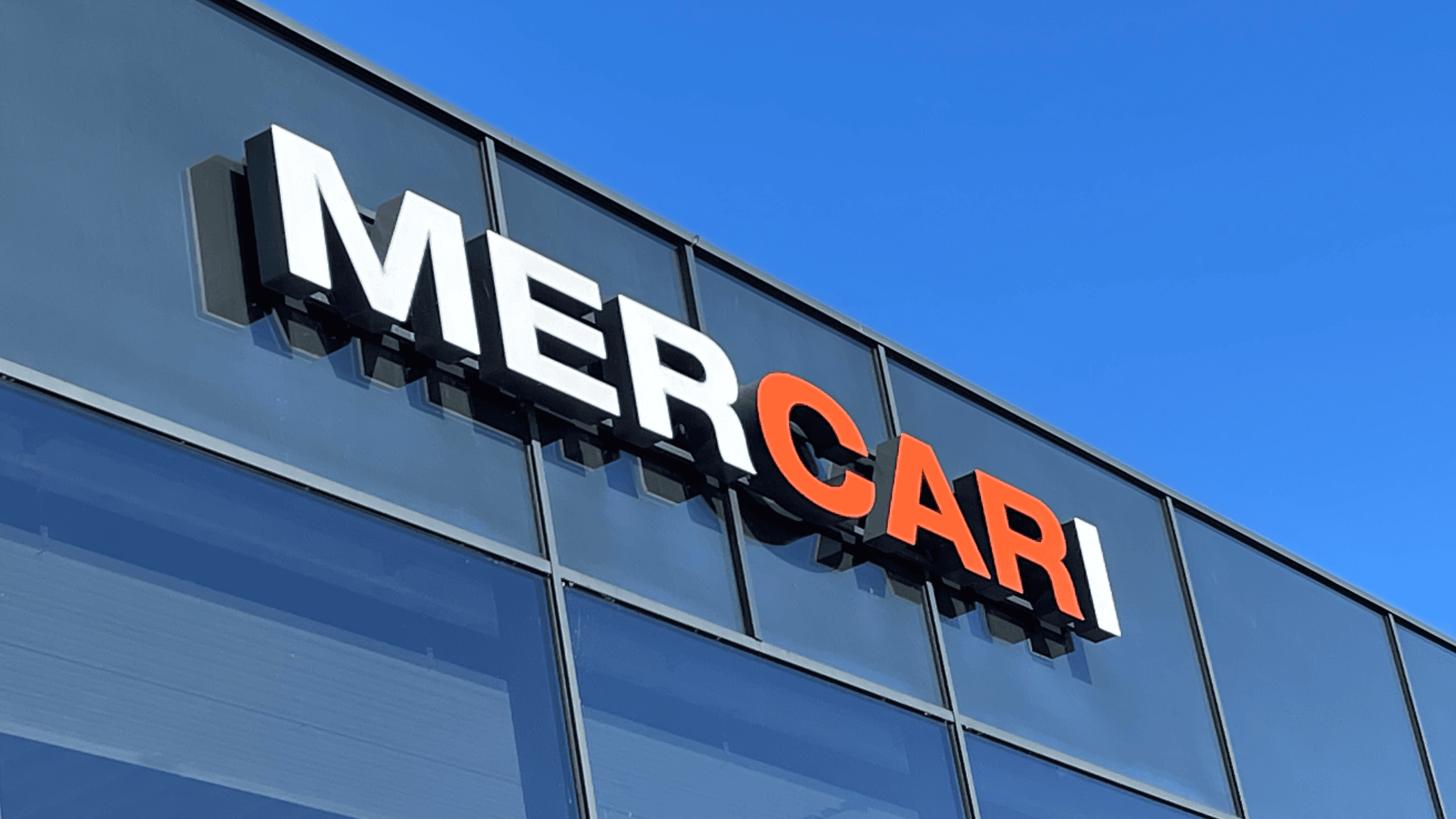 Facadeskilt fra Skomø med MERCARI logo i 3D-bogstaver monteret på glasfacade.